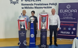 policjantka i dwaj mężczyźni po jej bokach pozują do zdjęcia, przed nimi stoją trofea