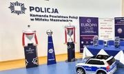 trzy trofea stoją przy ścianie z napisem Komenda Powiatowa policji w Mińsku Mazowieckim