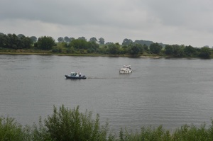 łódź turystów oraz łódź policyjna na rzece