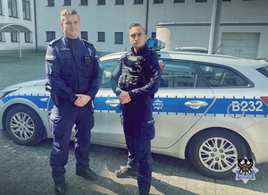 dwaj policjanci przy radiowozie