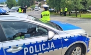 Policjanci podczas zabezpieczenia w Karpaczu, na pierwszym planie policjantka stojąca tyłem przy radiowozie
