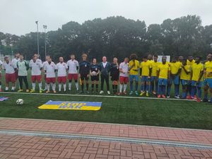 drużyny piłkarskie Reprezentacji Polskiej Policji oraz zawodników z Afryki stoją w szeregu na boisku
