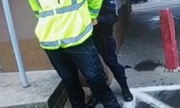 policjantka trzyma zatrzymanego mężczyznę