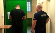 policjant z zatrzymanym na korytarzu aresztu