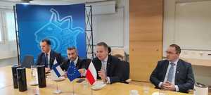 czterej mężczyźni siedzą za stołem. Na stole widać miniaturkę polskiej i finlandzkiej flagi