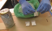 na zdjęciu zabezpieczone narkotyki w foliowych torebeczkach, obok stoi słoik wypełniony narkotykami