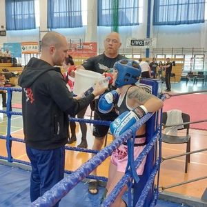 trener podaje wodę zawodniczce która stoi w roku ringu