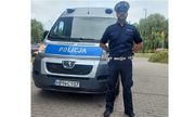 umundurowany policjant stoi przed radiowozem