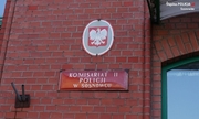 tabliczka Komisariatu II Policji w Sosnowcu na budynku, nad tabliczką godło z białym orzełkiem