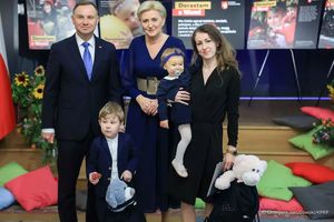 Prezydent Andrzej Duda I pani Prezydentowa Agata Duda pozują do zdjęcia z kobietą trzymająca na ręku małą dziewczynkę. przed nimi stoi mały chłopiec