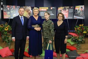 Prezydent Andrzej Duda I pani Prezydentowa Agata Duda pozują do zdjęcia z podopieczną Fundacji Dorastaj z Nami. Wraz z nimi stoi kobieta w okularach