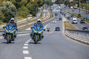 dwaj policyjni motocykliści na jezdni na ulicy miasta