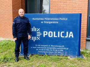 umundurowany policjant pozuje do zdjęcia na tle ścianki z napisem: Komenda Powiatowa Policji w Stargardzie, Policja