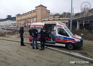 ambulans pogotowia ratunkowego przy który stoją dwaj policjanci, uratowany mężczyzna i dwaj ratownicy medyczni