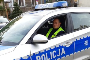 policjant na miejscu kierowcy siedzi w radiowozie