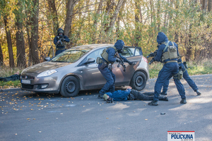 Policyjni kontrterroryści w trakcie akcji dynamicznego zatrzymania kierowcy samochodu osobowego.