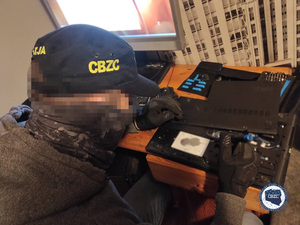 Policjant CBZC przed klawiaturą komputera