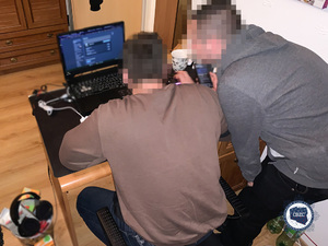dwaj policjanci przed klawiaturą komputera