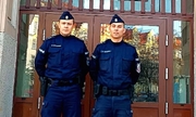 dwaj policjanci stoją przed wejściem do Komisariatu Policji Szczecin-Niebuszewo