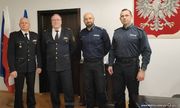dwaj niemieccy i dwaj polscy policjanci pozują do zdjęcia w pomieszczeniu