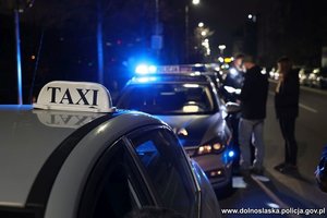policjanci podczas kontroli drogowej taksówkarza