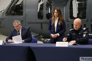 Komendant Główny Policji wraz z Prezesem PZL Mielec siedzą wspólnie przy stole i podpisują umowę