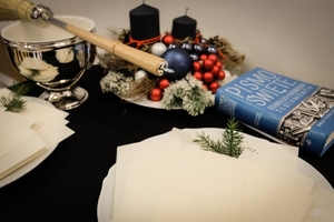 na stole leżą: pismo święte, talerze z opłatkiem, kropielnica z kropidłem