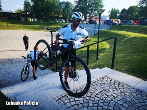 Policjant przenosi rower