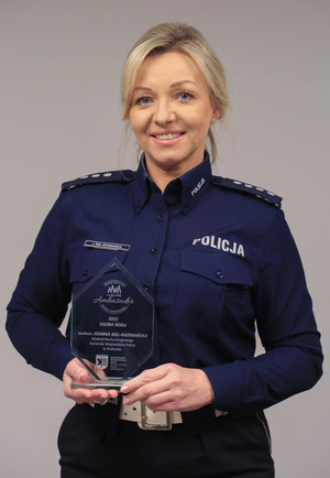 Nadkomisarz Joanna Biel - Radwańska w mundurze pozuje do zdjęcia i trzyma w ręku statuetkę