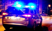 Zdjęcie przedstawiające radiowóz policyjny z włączonymi sygnałami pojazdu uprzywilejowanego