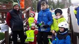 dzieci z opiekunem na stoku narciarskim