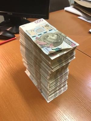 na biurku banknoty o nominale 500 zł ułożone jedne na drugich