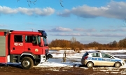wóz strażacki i radiowóz policyjny w miejscu poszukiwań zaginionego mężczyzny