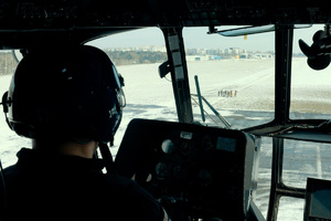 Pilot w kabinie śmigłowca obserwuje widocznych w dole strażaków.