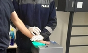 policjant pobiera odciski palców od mężczyzny