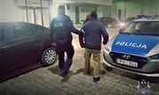 umundurowany policjant prowadzi do komisariatu odnalezionego mężczyznę