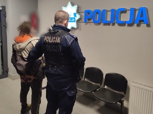 policjant z zatrzymanym zakutym w kajdanki