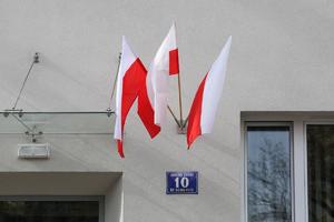 trzy biało - czerwone flagi na budynku