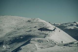 Na tle pokrytych śniegiem gór lewa burta lecącego Black Hawka.