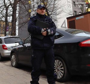 umundurowany policjant stoi przy samochodzie