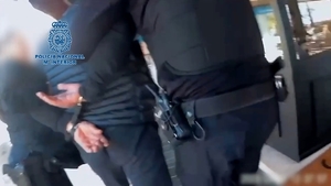policjanci z zatrzymanym mężczyzną skutym w kajdanki