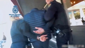 policjanci z zatrzymanym mężczyzną skutym w kajdanki