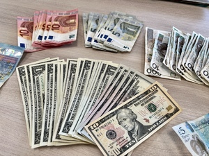 Zdjęcie przedstawia banknoty w różnych nominałach rozłożone na stole.