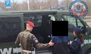 policjantka i funkcjonariusz Żandarmerii Wojskowej prowadzą zatrzymanego do samochodu żandarmerii