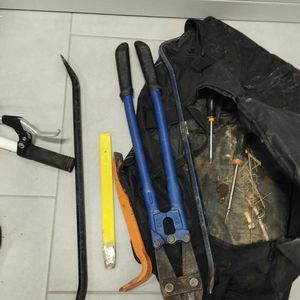 Zdjęcie przedstawia zabezpieczone przedmioty, tj. narzędzia i czarną torbę.