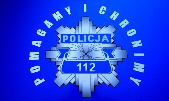 Zdjęcie przedstawia niebieski plakat z białym napisem POLICJA.