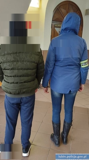 policjantka prowadzi nieletniego - widok z tyłu