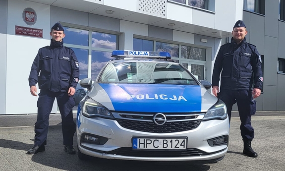 dwaj policjanci przy radiowozie