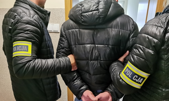 policjanci prowadzą zatrzymanego mężczyznę