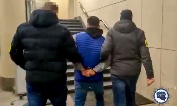 dwaj funkcjonariusze CBZC prowadzą zatrzymanego mężczyznę